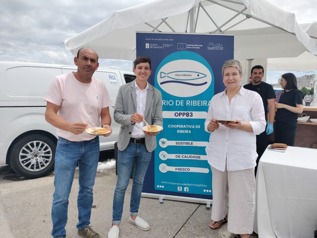 El alcalde y concejal de Mar de Ribeira, Luis Pérez y Fernando Abraldes, con la gerente de la OPP83, María José Casais, durante la degustación gratuita de Lirio de Ribeira en el XVII Encontro de Embarcacións Tradicionais de Galicia